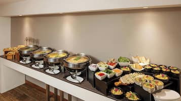 A buffet with various food items and utensils.
