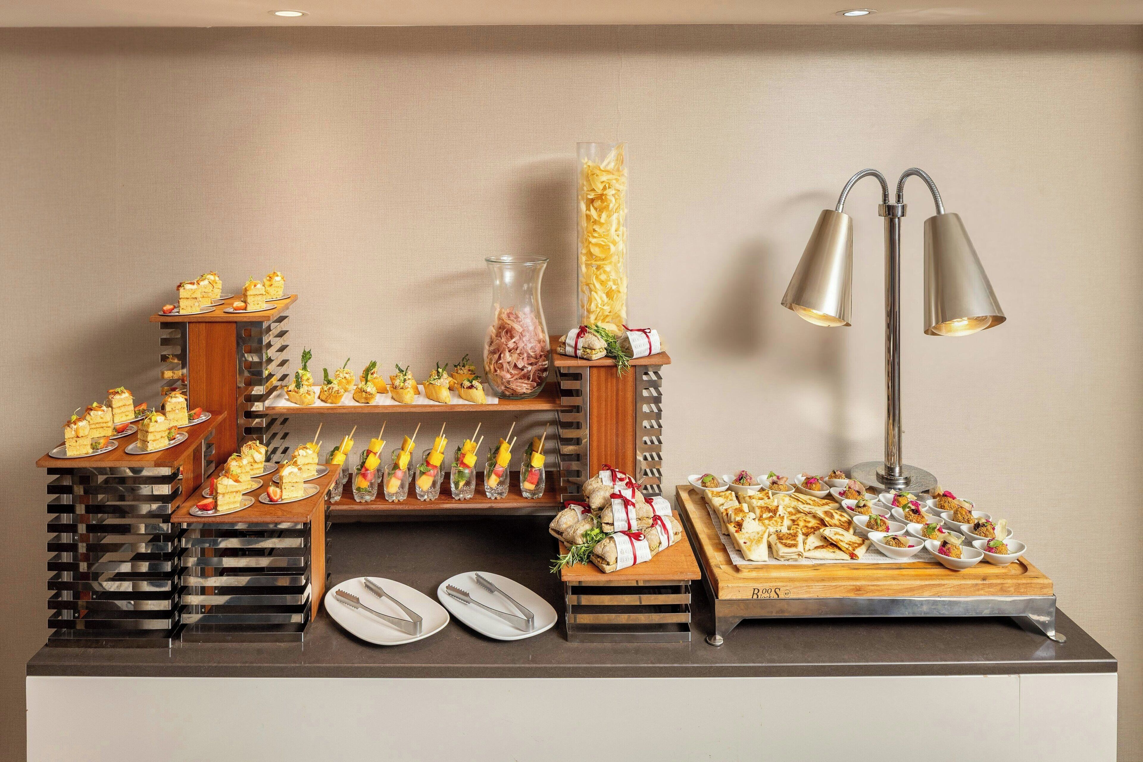 A buffet setup with various food items and a lamp.