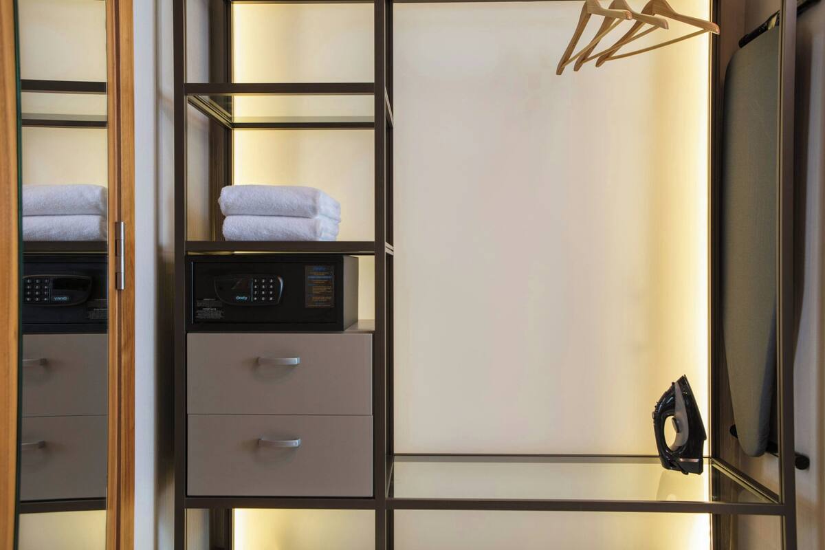 Ein Hotelzimmer mit Minibar, Mikrowelle und Schubladen.