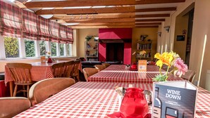 A restaurant with red and white checkered tablecloths, wooden chairs, and a red pitcher on the table. - YHA Helmsley - Hostel (York)