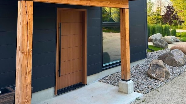 A modern two-story house with a dark exterior, large windows, and a wooden porch. - Orchard Run Chalet (The Blue Mountains)