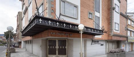 A building with a balcony, a gated entrance, and a sign for "Ricardo Hotel".