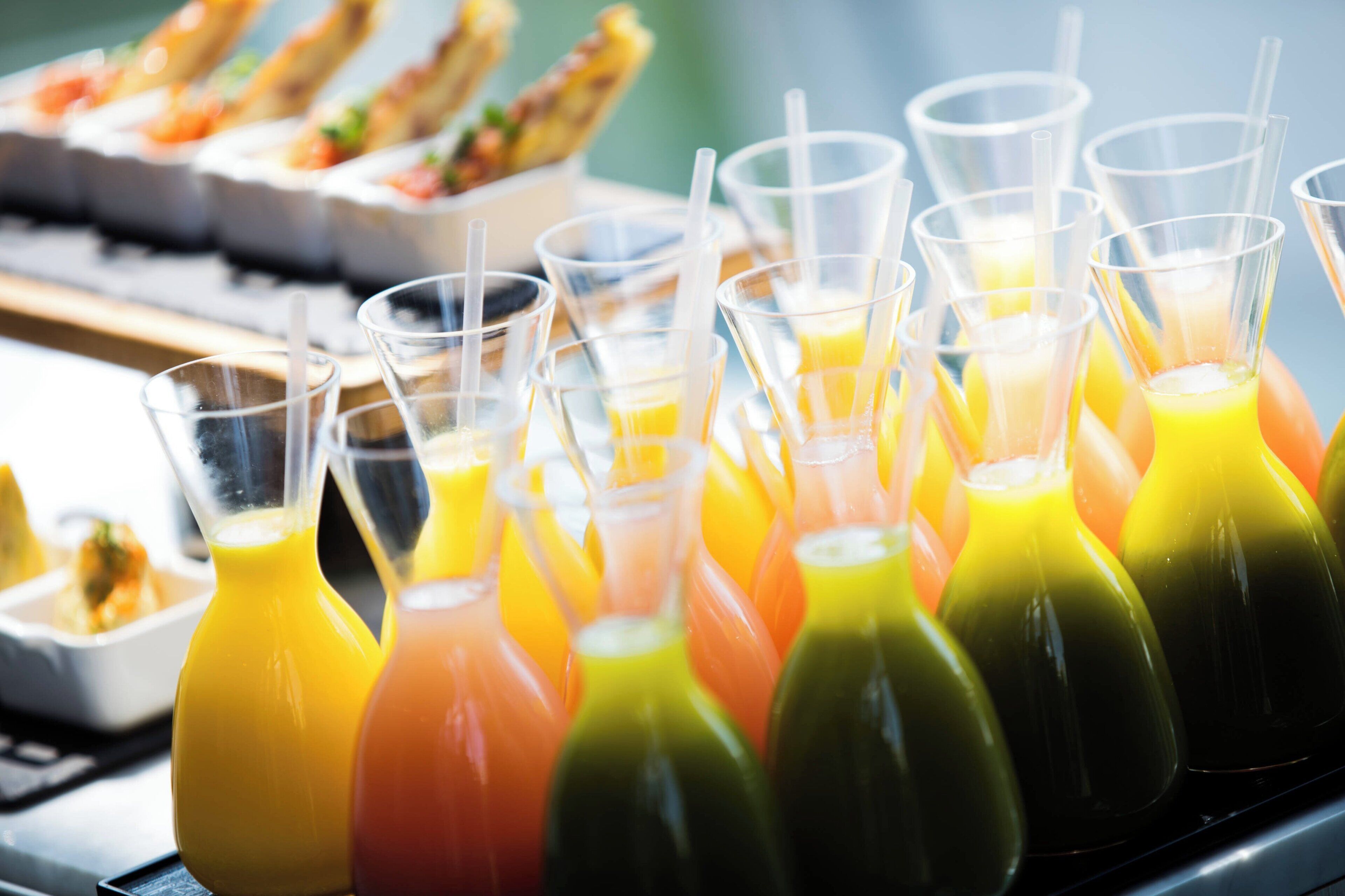Un buffet proposant une variété de plats et de boissons colorées servies dans des verres transparents.