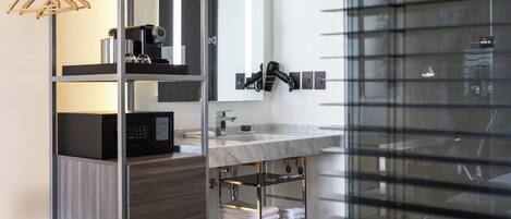A modern bathroom with a glass shower enclosure, a vanity with a marble countertop, and a towel rack.