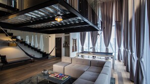 Una sala moderna con un sofá, una mesa de centro y una mesa de billar.