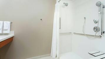 Un baño moderno con ducha, inodoro y lavamanos.