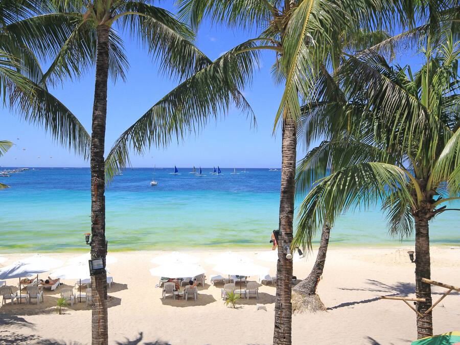 En la playa, arena blanca, sillas reclinables de playa