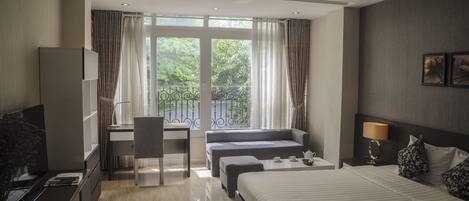 Habitación Deluxe, vistas a la ciudad | Minibar, caja fuerte, escritorio y cortinas opacas