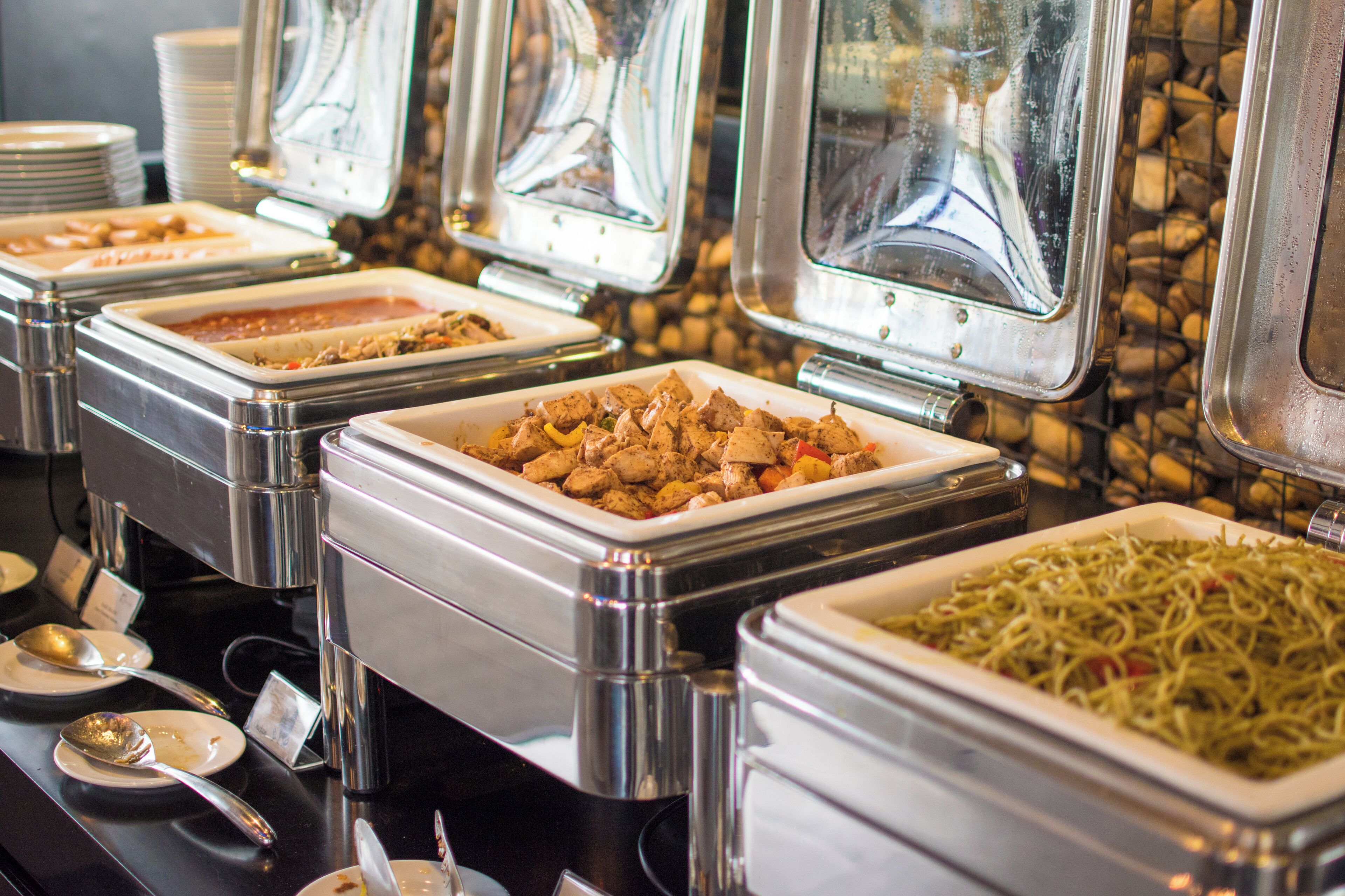 Buffet mit verschiedenen Speisen in Metallbehältern.