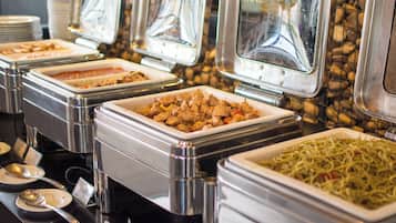 Buffet mit verschiedenen Speisen in Metallbehältern.