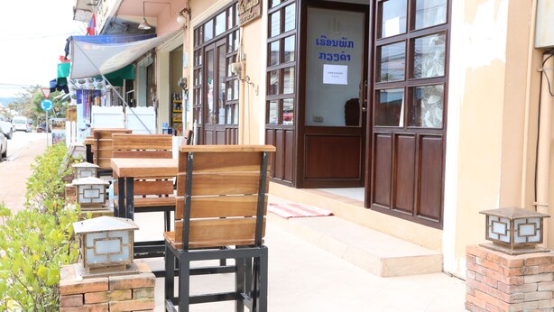 Un restaurant doté d’une terrasse, de piliers en briques et d’une enseigne dans une langue étrangère.