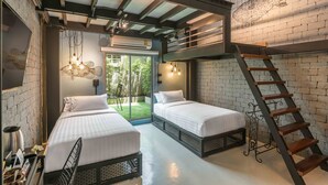 Een moderne hotelkamer met twee bedden, een trap en een groot raam met uitzicht op groen.