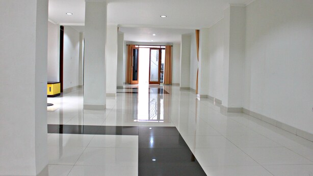 Un corredor de hotel moderno y espacioso, con piso pulido, ventanas grandes y vistas al exterior.
