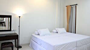 Una habitación de hotel con cama, escritorio y espejo.