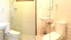 Un baño con inodoro, bidé y lavamanos.