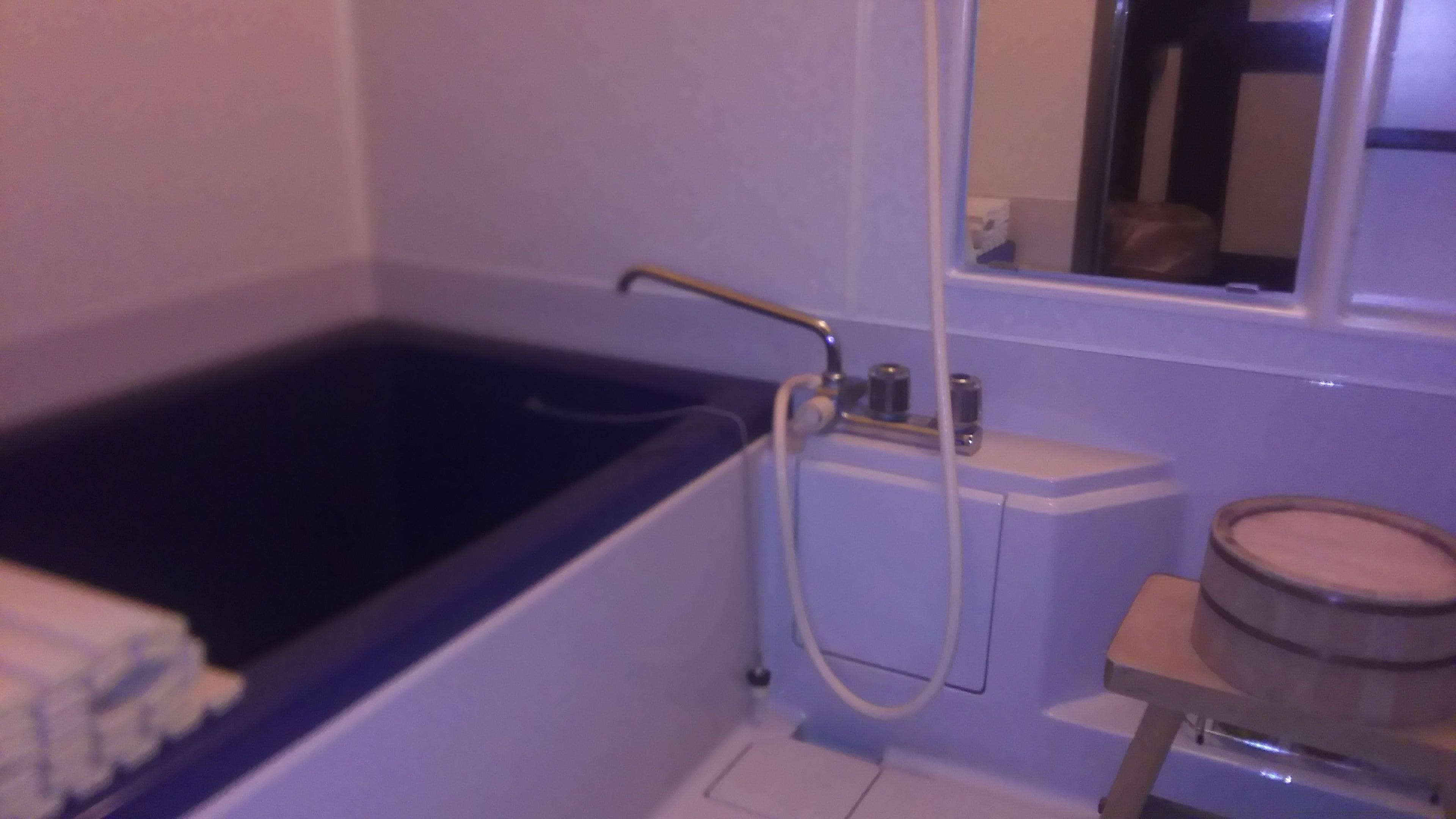 Une salle de bain avec une baignoire, des toilettes et un tonneau en bois.