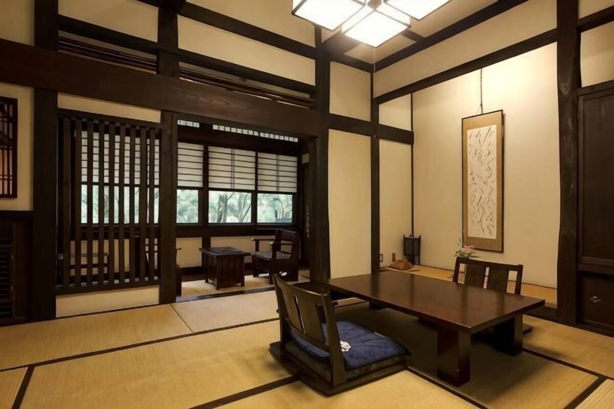 A traditional Japanese room with tatami flooring, a low table, and sliding doors.