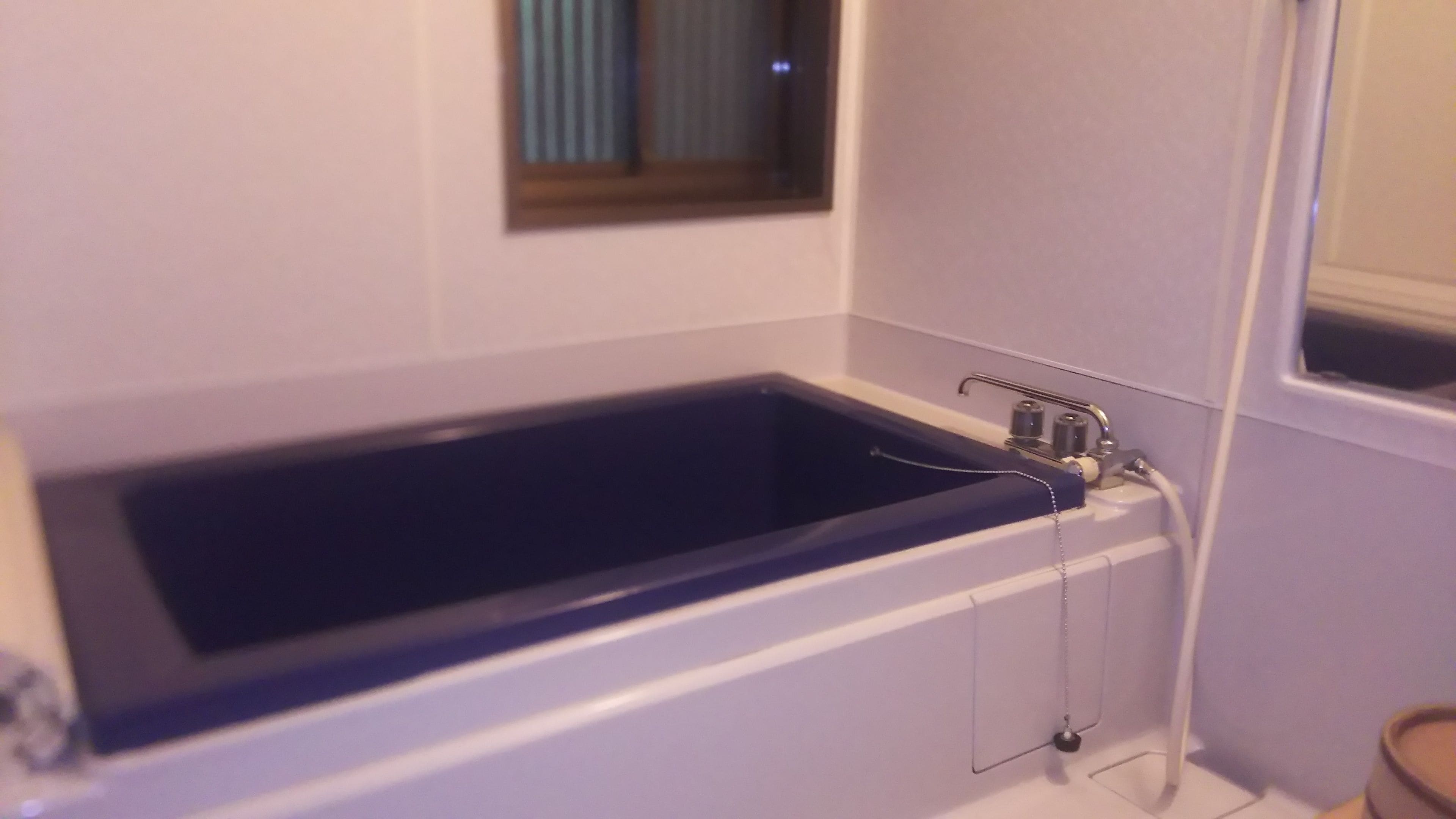 Un baño con bañera, ventana y zona de ducha.