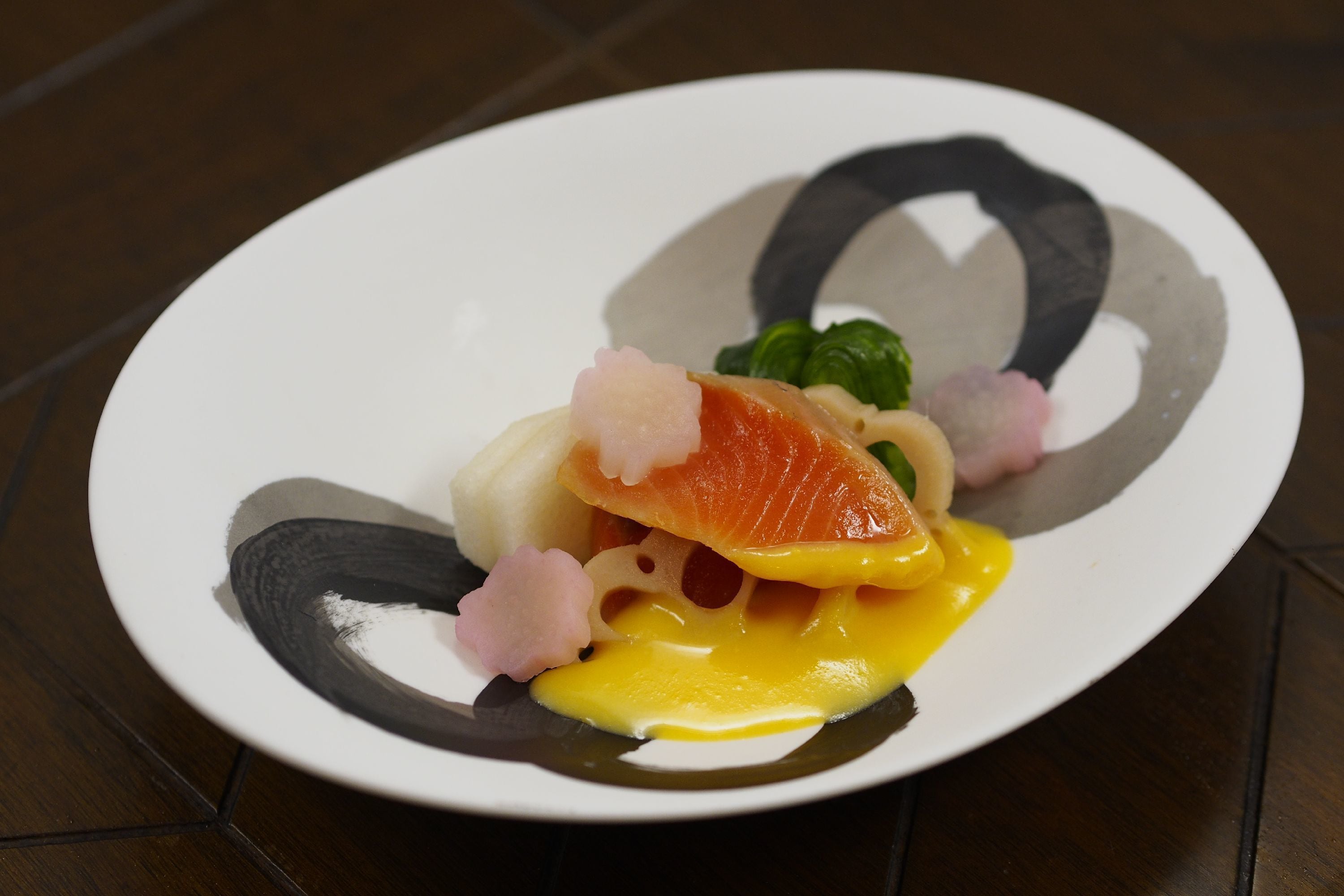 Een bord met een gerecht bestaande uit zalm, ei en groenten.