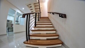 A modern staircase with wooden steps and black railings, leading to an upper floor. - De Orion Setiabudi Villa (Bandung)
