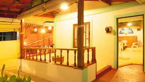 A staircase with a wooden railing leading to a room with a green door. - Masfalhi View Inn (Felidhoo)