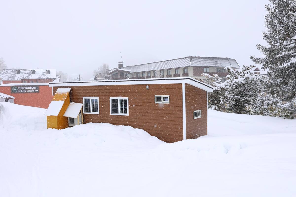 A brick building with a snow-covered roof and a sign that reads "RESTAURANT".