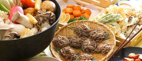 A variety of food items including vegetables, mushrooms, and noodles arranged on a table.
