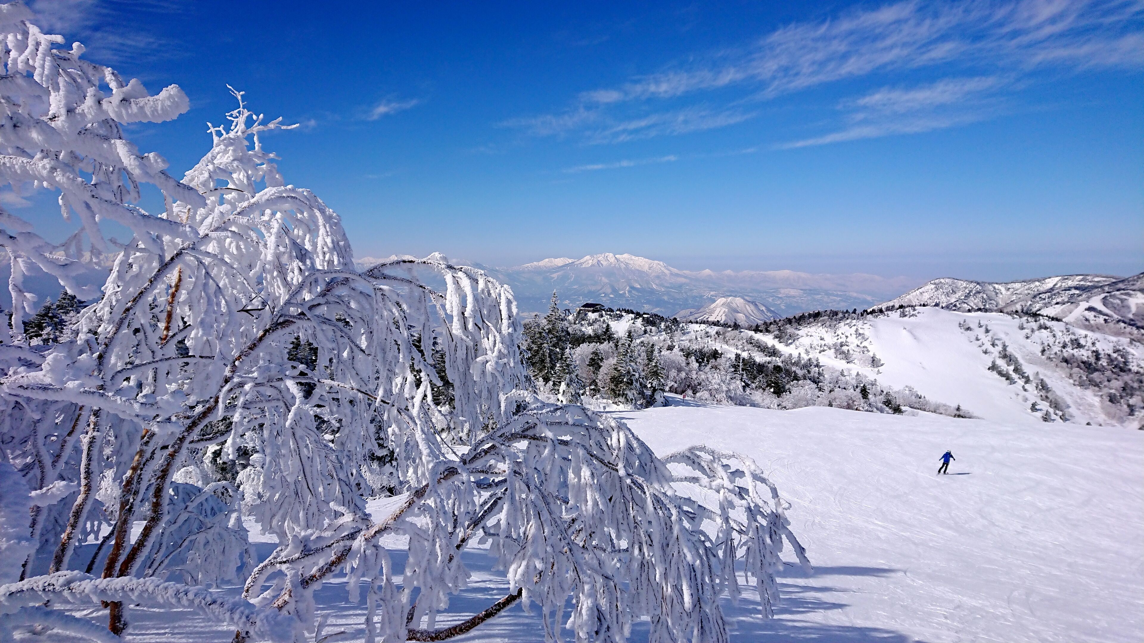 Eine verschneite Berglandschaft mit blauem Himmel.