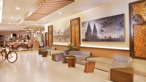 A modern lobby with seating areas, a bicycle, and artwork on the walls.