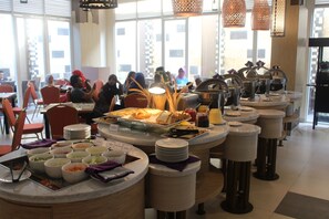 Una mesa de buffet con diversos alimentos y utensilios para servir.