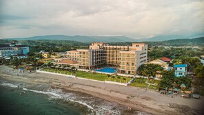 Un complejo turístico con piscina, playa y varios edificios.