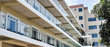 A multi-story hotel with balconies, a paved entrance, and a sign that reads "Awesome".