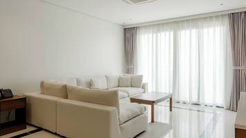 A modern living room with a sofa, a small table, and a telephone on a side table.