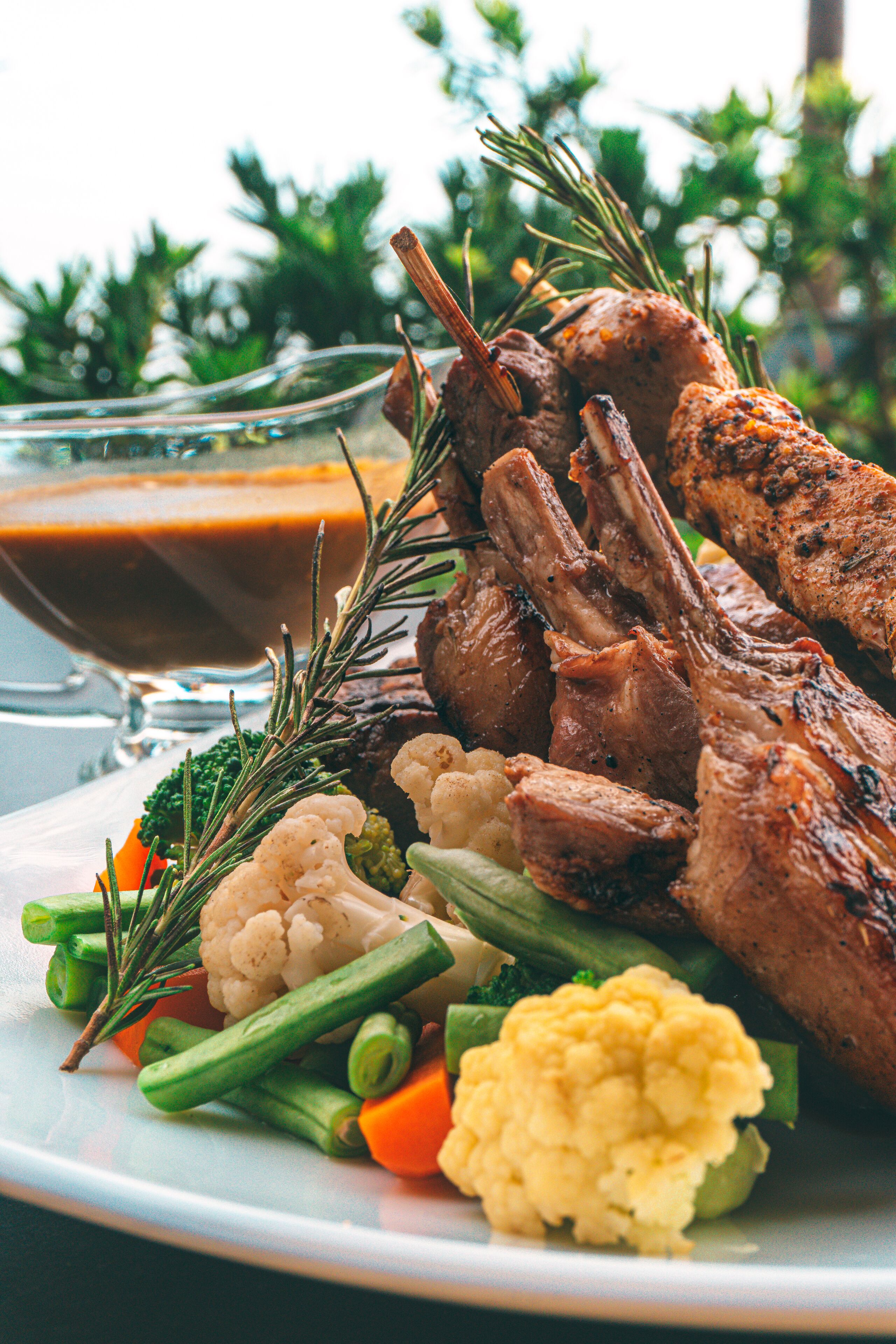 A plate of roasted meat with vegetables and gravy.