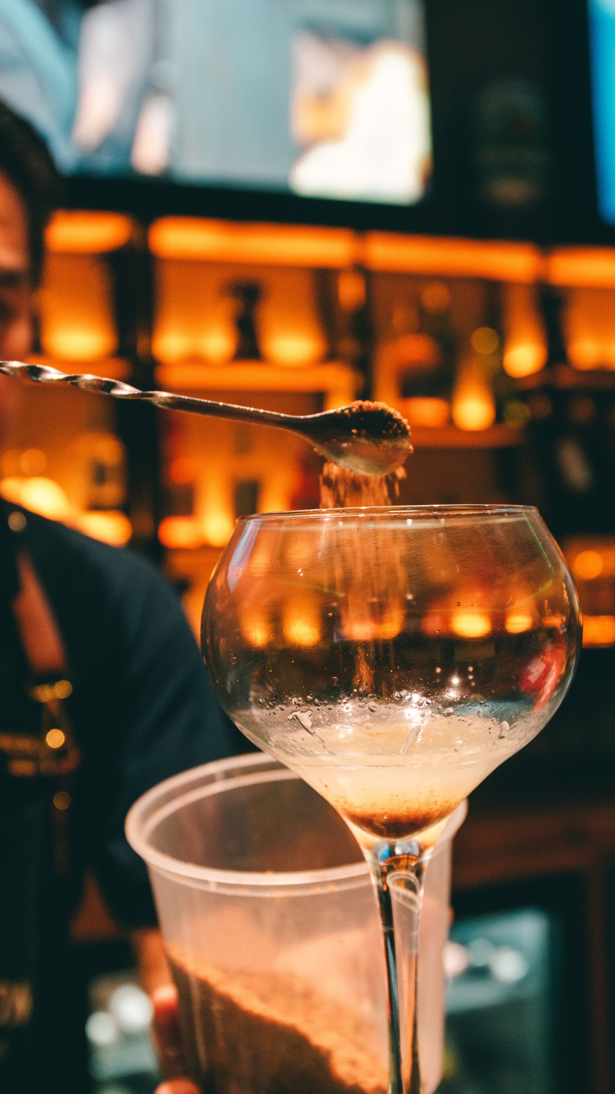 A bar setting with a martini glass and a cocktail shaker.