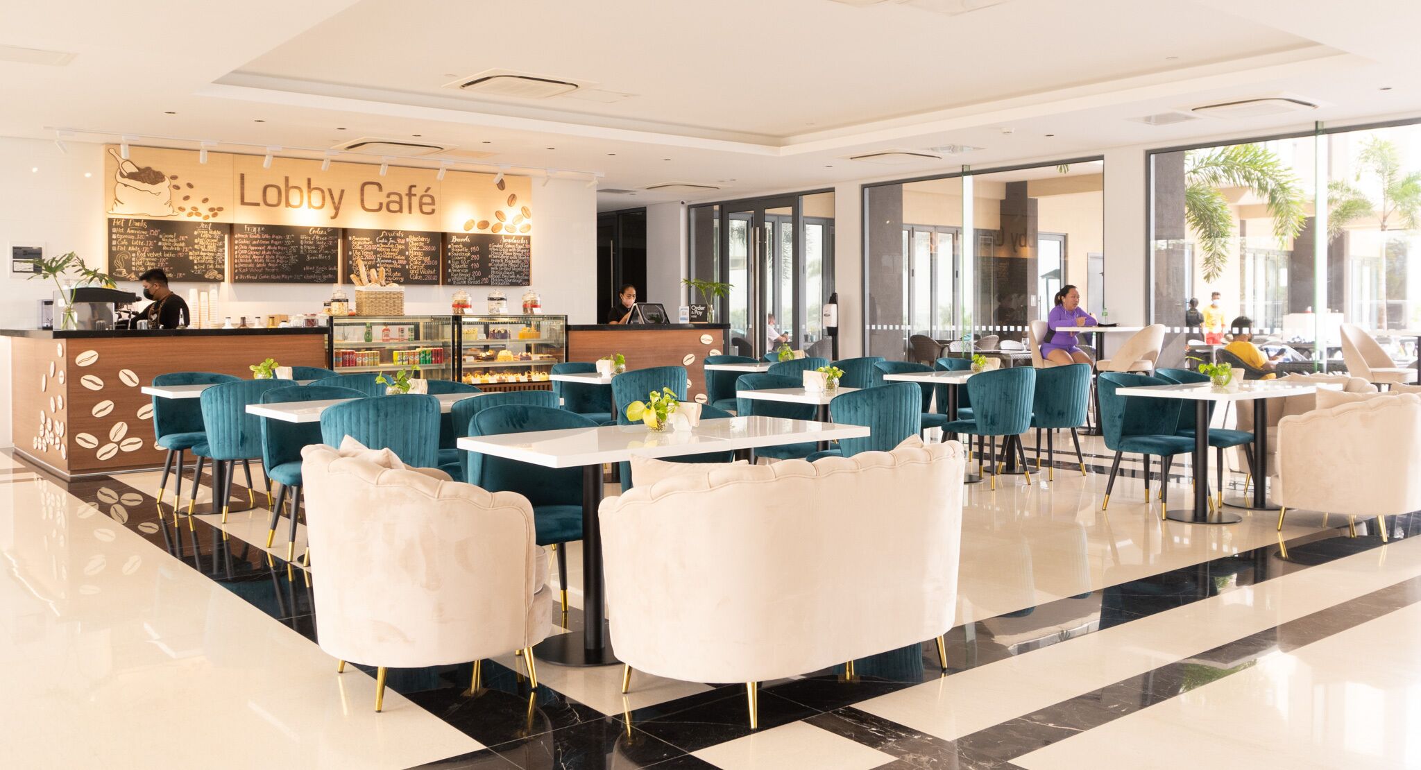 A modern lobby with a coffee bar, seating area, and large windows.