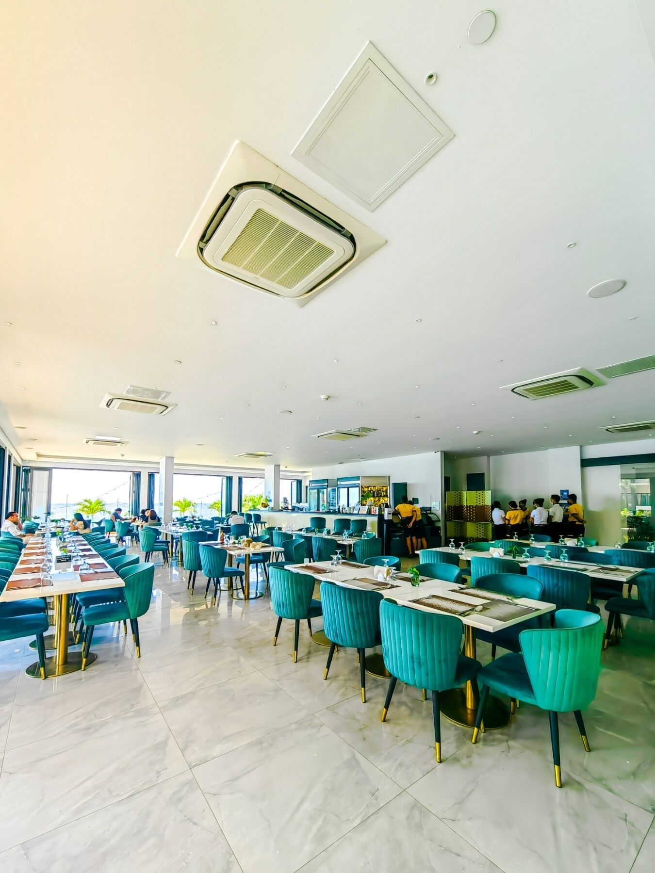 A spacious restaurant with high ceilings, modern lighting, and a clean, organized layout.