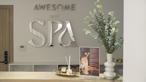 Una zona de recepción con un cartel que dice "AWESOME HOTEL SPA" y un cartel promocionando un servicio de spa.