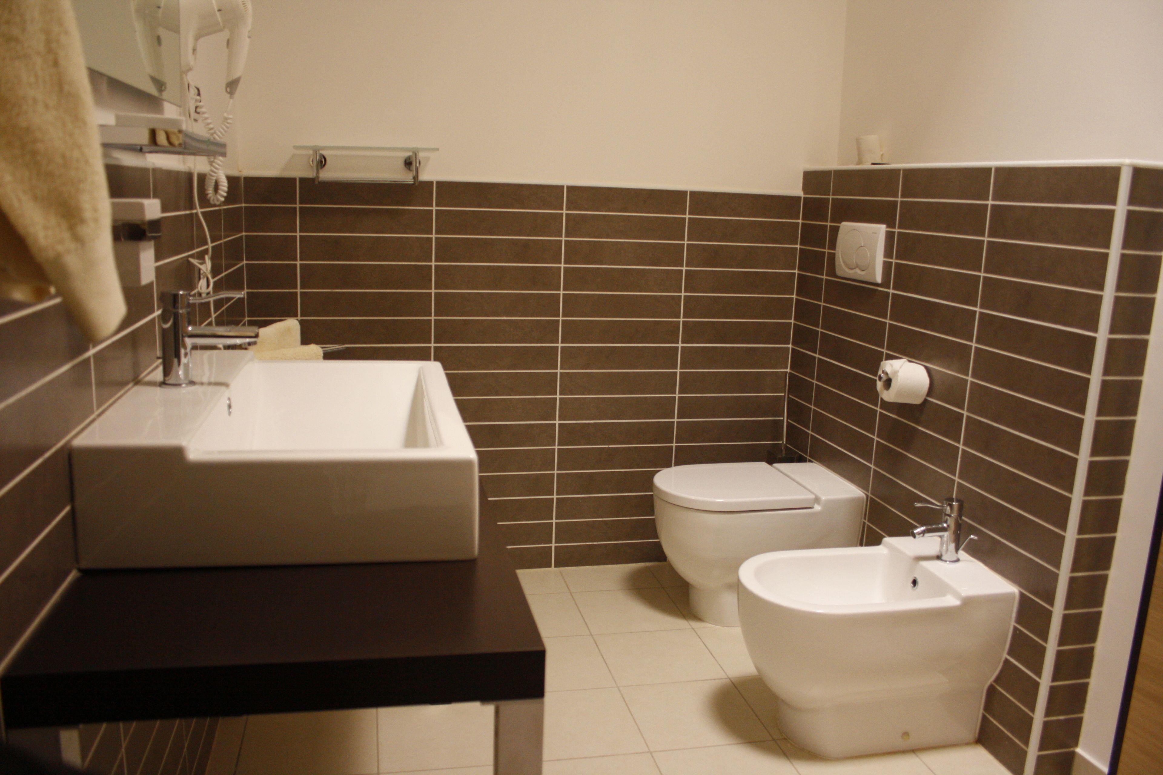 Un baño moderno con un lavabo grande, inodoro y bidé.