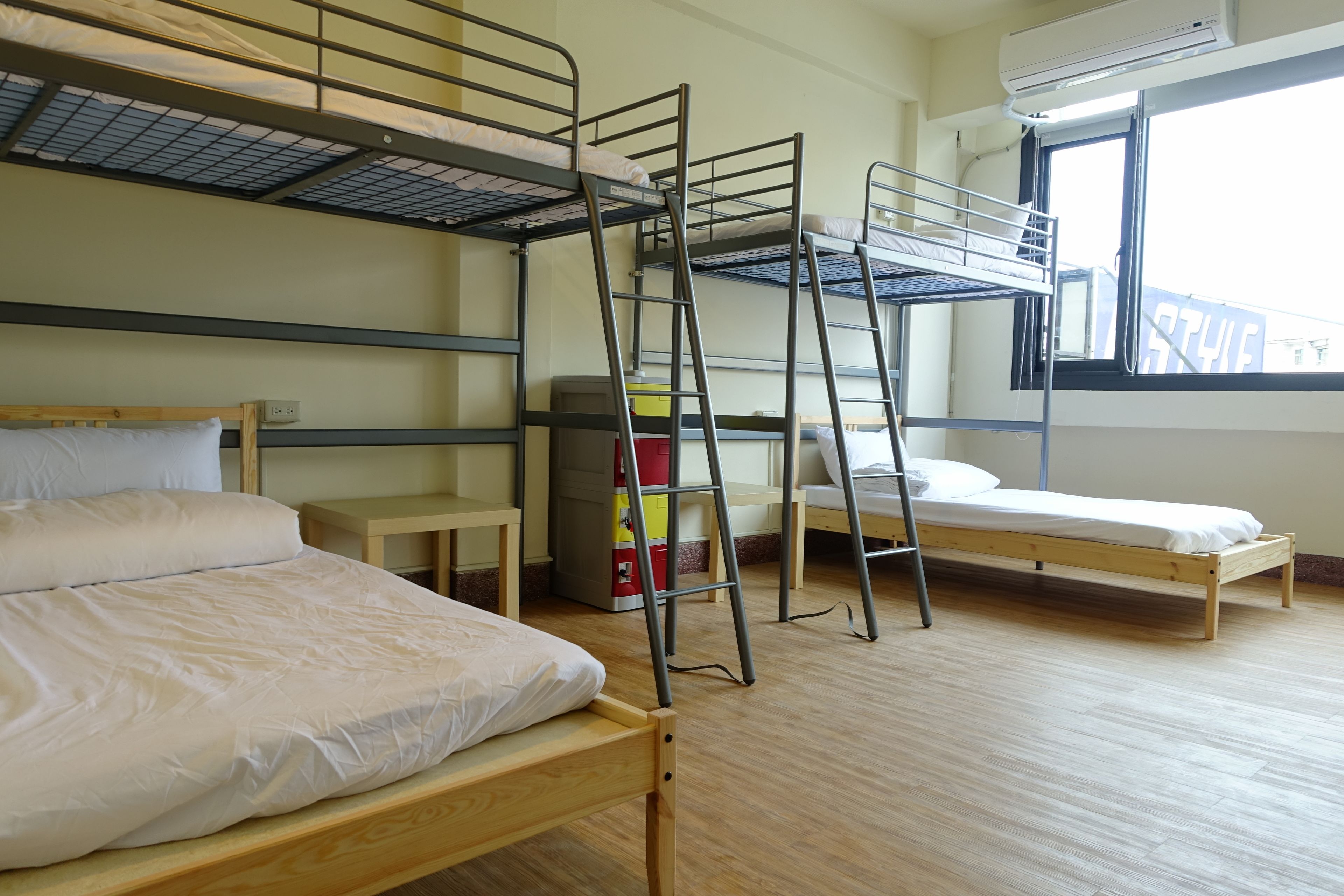 Un dormitorio con literas, un escritorio de madera, una silla y una ventana con vistas.