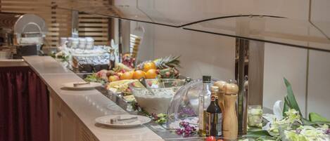 A buffet with various food items and condiments.