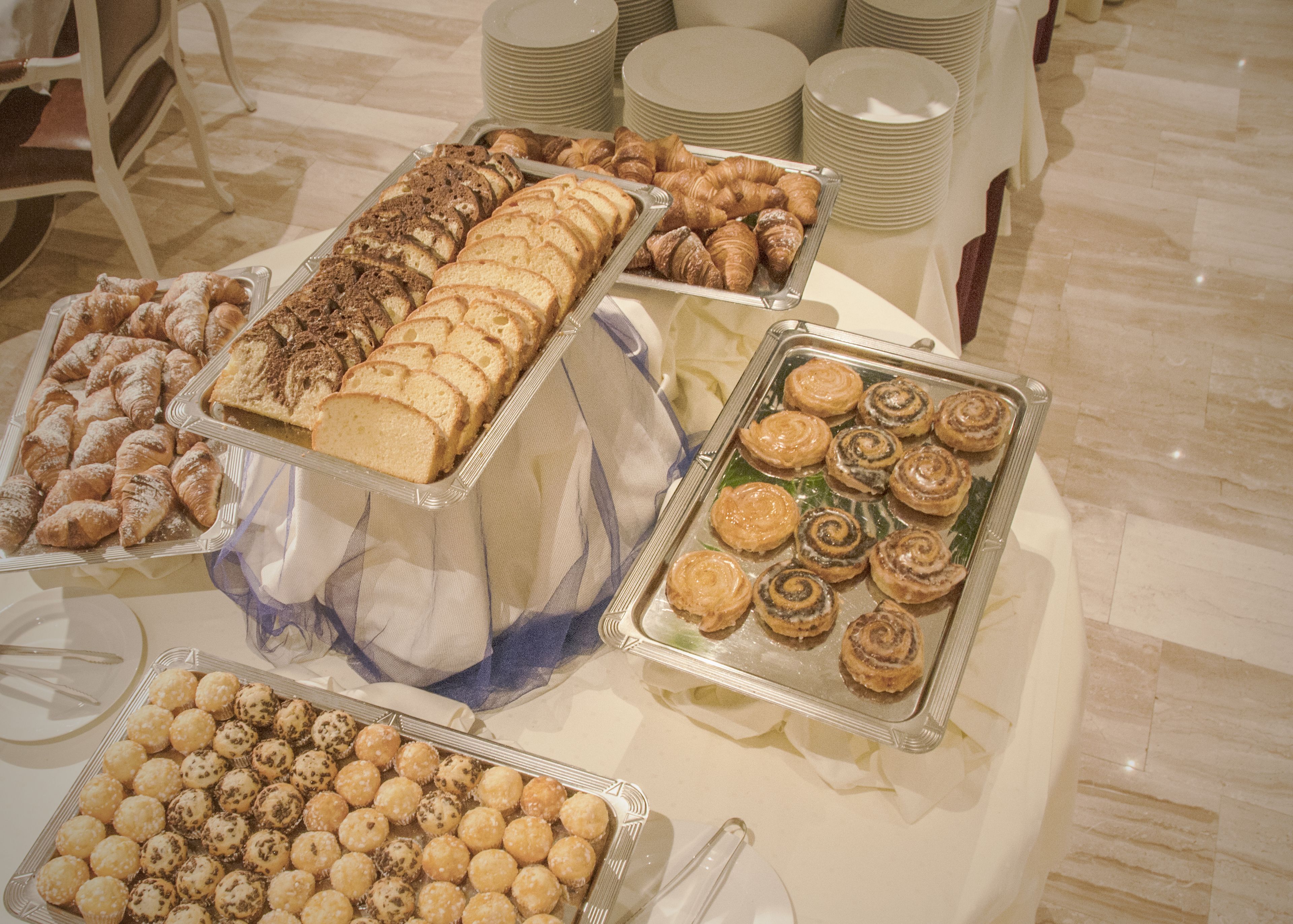 Uma mesa de buffet com diversos doces e sobremesas.