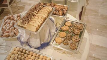 Uma mesa de buffet com diversos doces e sobremesas.