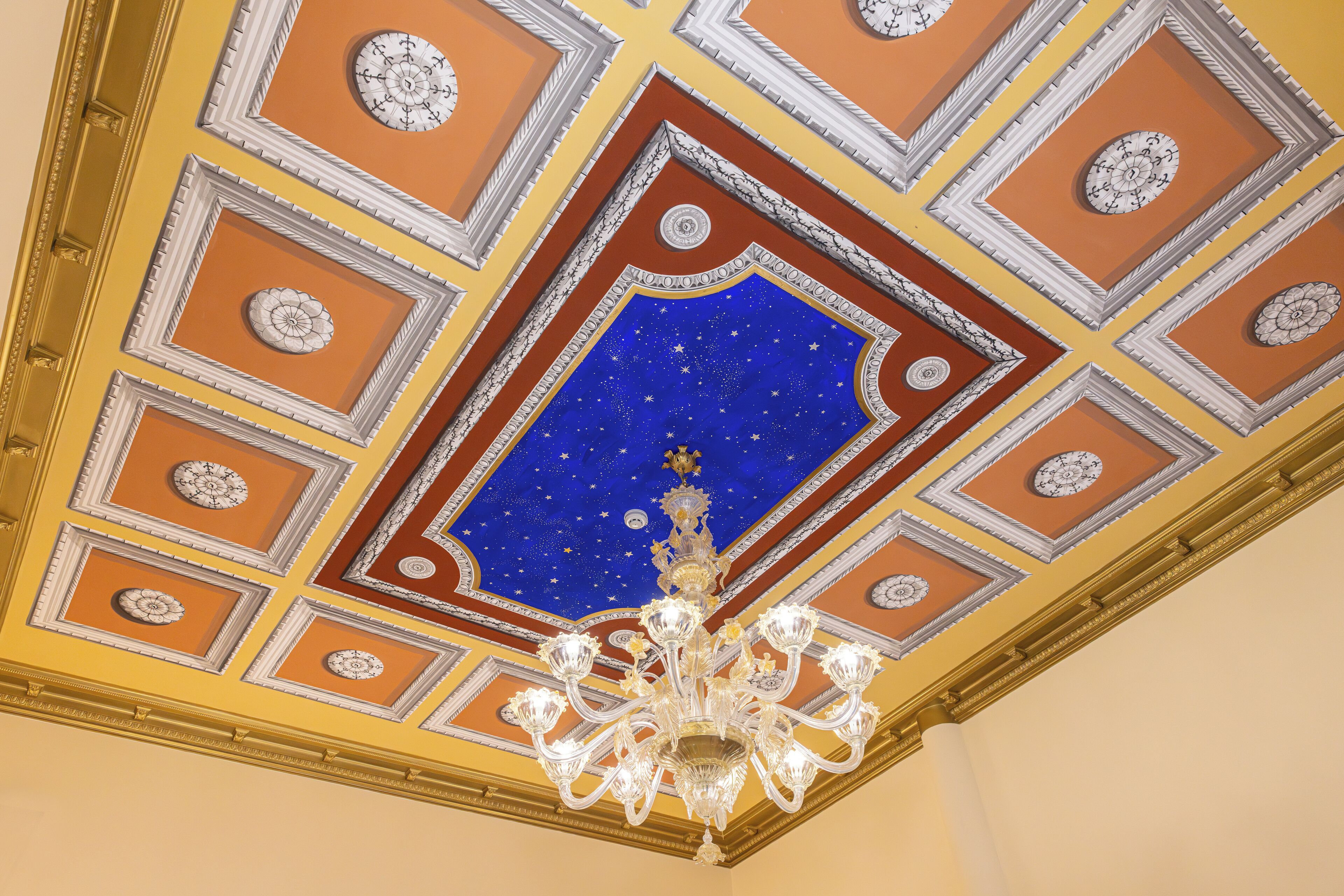Un plafond orné de motifs géométriques et d’un motif central représentant des étoiles.