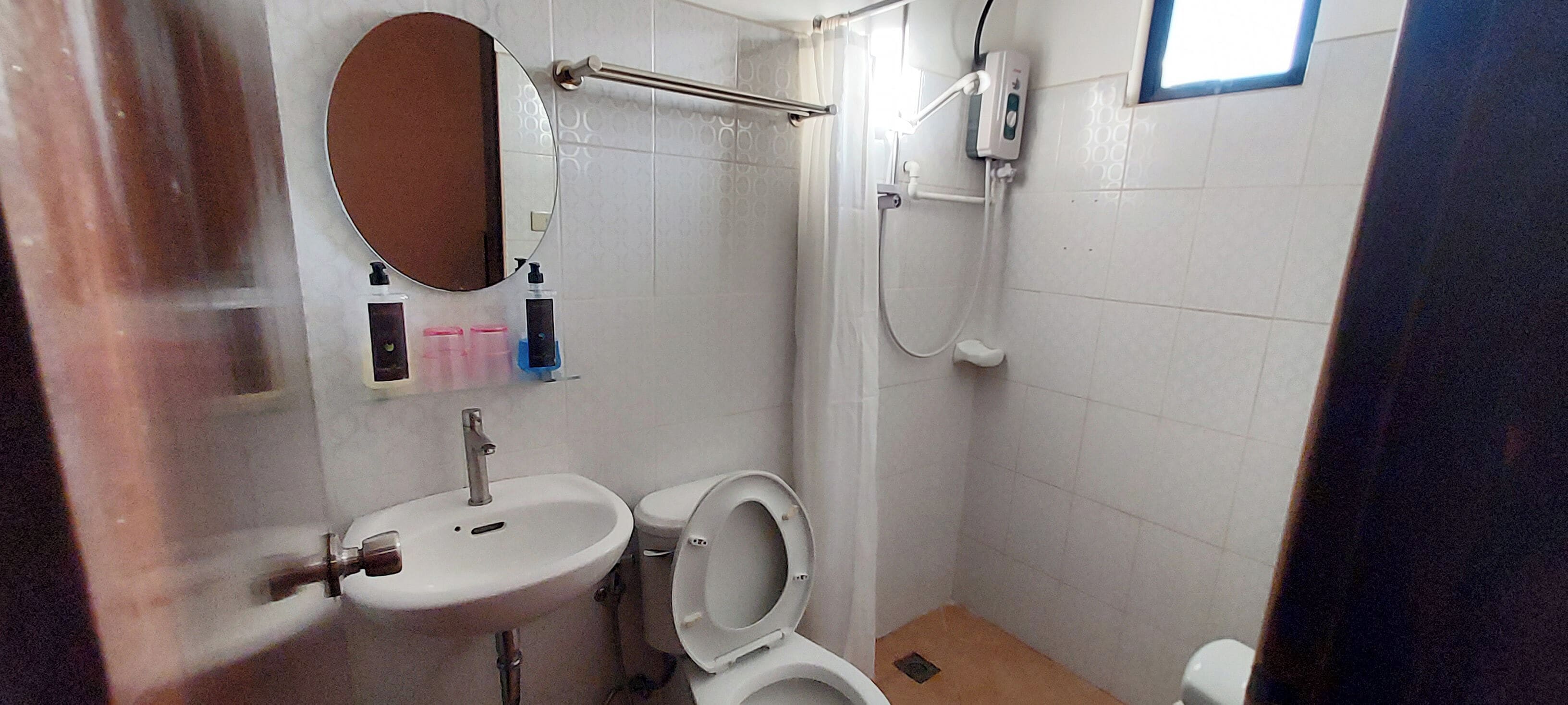 A small bathroom with a sink, toilet, and shower.