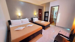 A hotel room with two beds, a small table, and a chair. - Coron Vista Lodge (Coron)