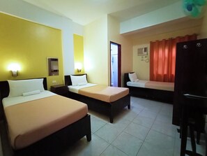 A hotel room with two beds, a desk, and a bathroom visible through an open door. - Coron Vista Lodge (Coron)