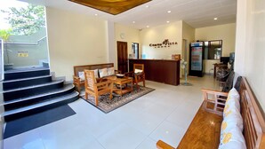 A hotel lobby with a reception desk, a staircase, and seating areas. - Coron Vista Lodge (Coron)