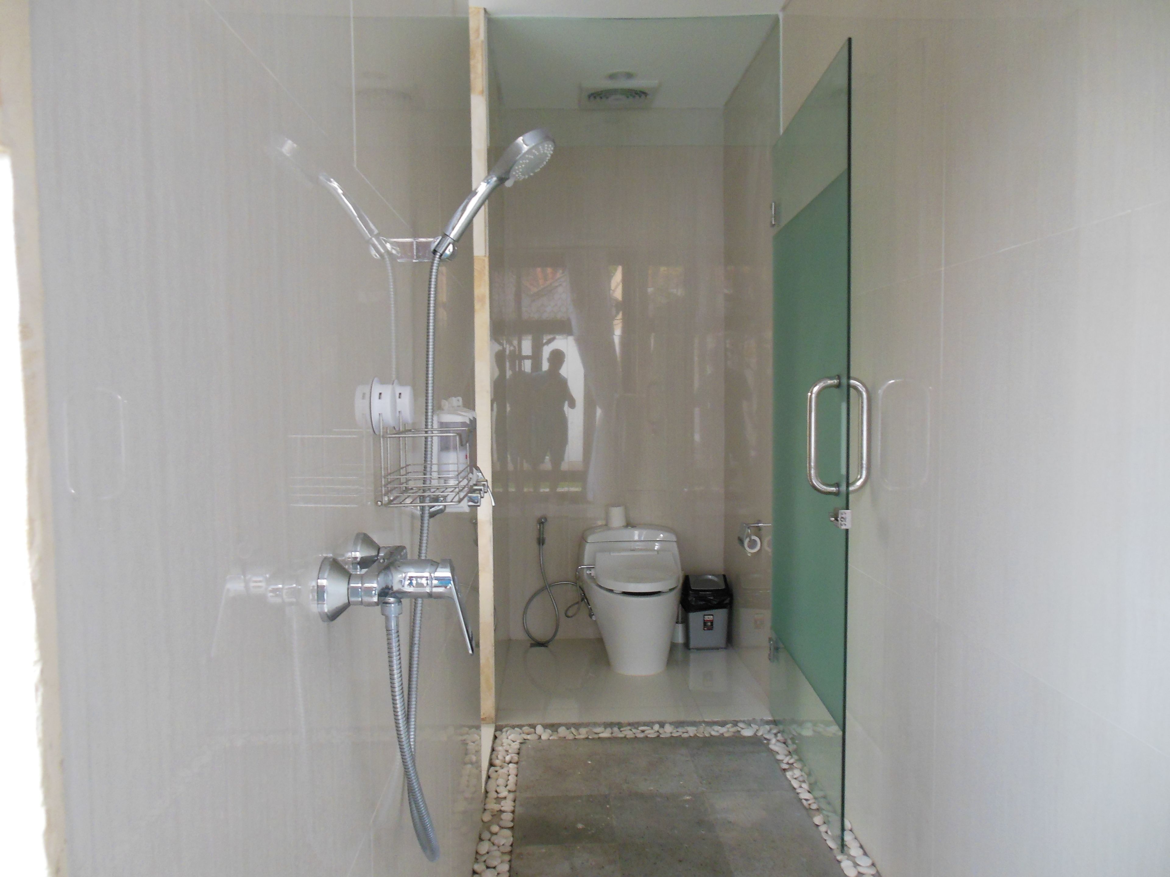 Une salle de bain moderne avec une douche à parois de verre, des toilettes et un bidet.