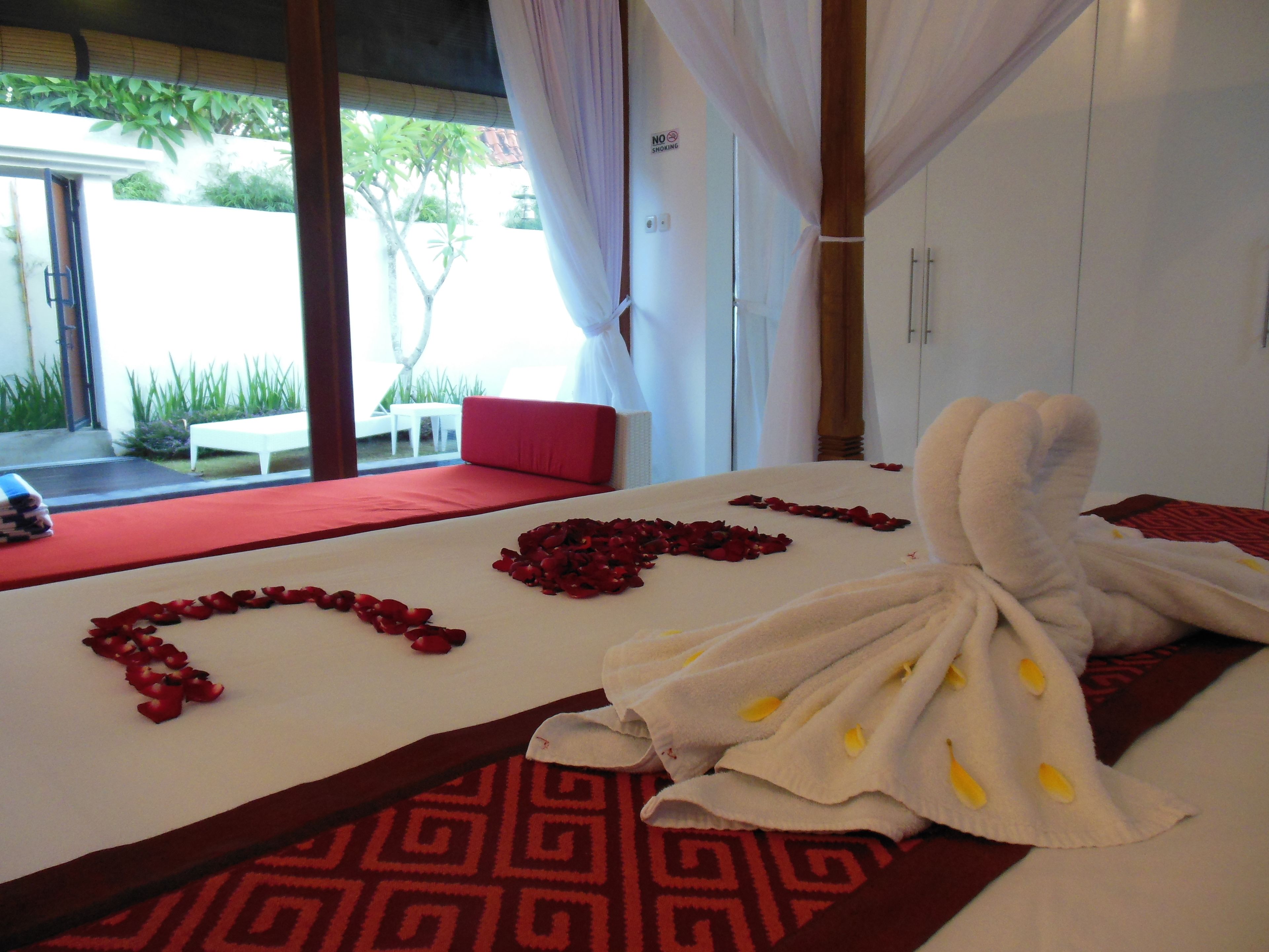 Ein Hotelzimmer mit einem Bett, einem rot-weißen Teppich und einem Handtuch mit gelben Akzenten.